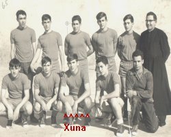 School handball team with a priest